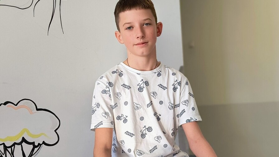 Пацієнт Арсен сидить у холі дитячої лікарні святого Миколая