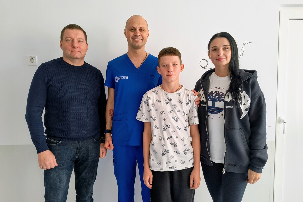 У холі дитячої лікарні стоять: батько пацієнта Леонід; інтервенційний онколог Святослав Балака; пацієнт Арсеній; мама пацієнта Людмила